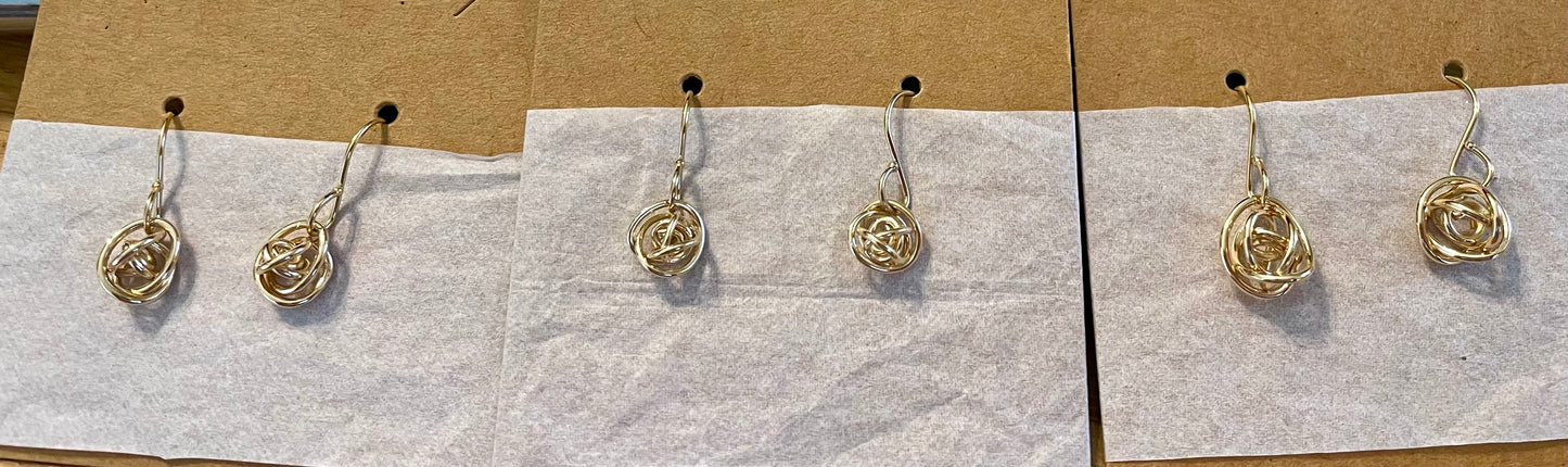 Small and Medium size gold fill knot earrings shown on cands