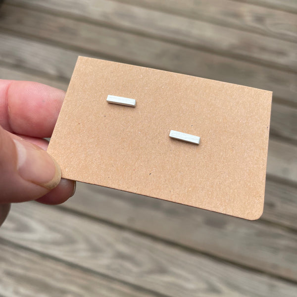 bar post earrings shown on brown card