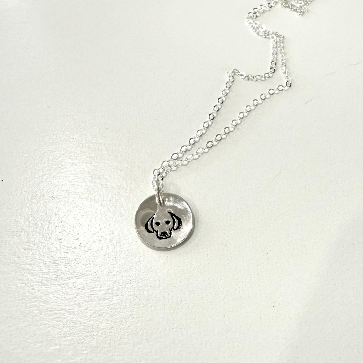 Dog face on silver circle pendant on chain