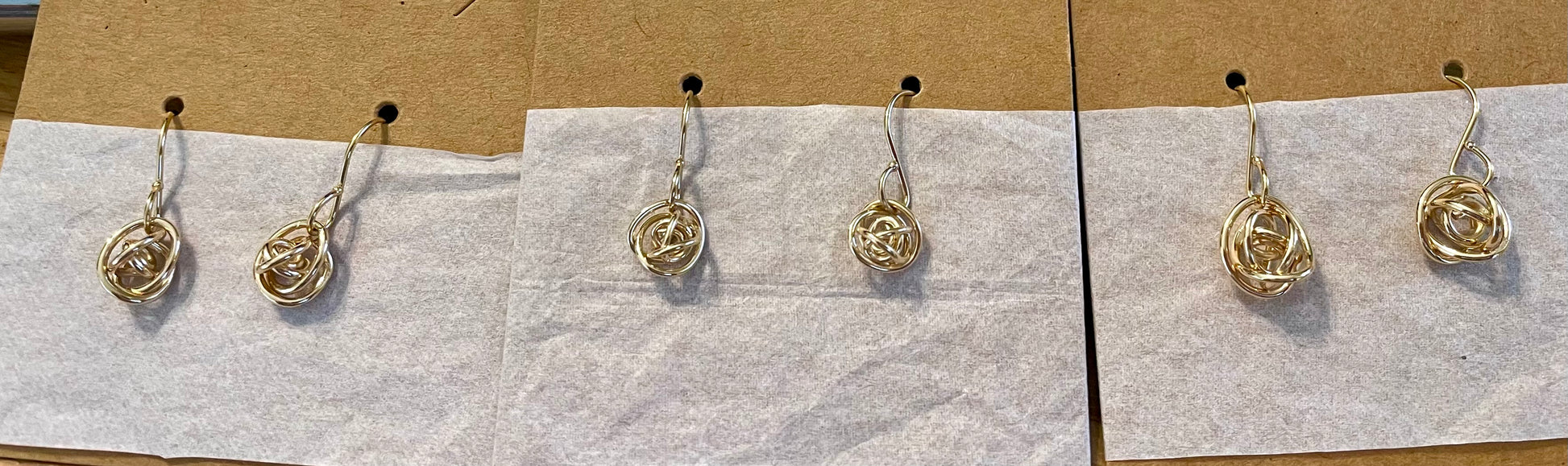 Small and Medium size gold fill knot earrings shown on cands