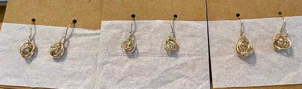 Small and Medium size gold fill knot earrings shown on cands
