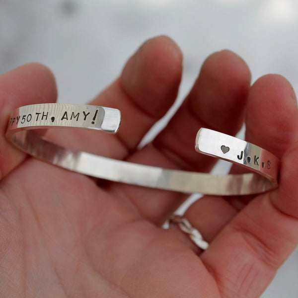 Underside of top of Trees Bracelet personalization close up in hand.