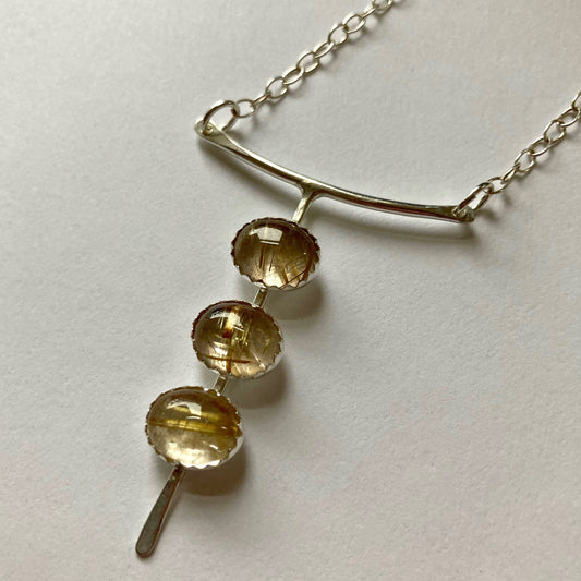 Rutilated Quartz three stone necklace shown on white background