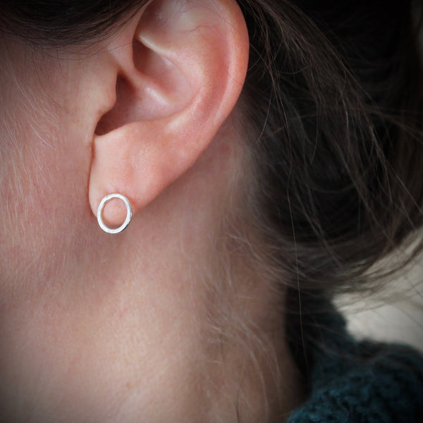 Small Silver Circle Post earrings shown on ear