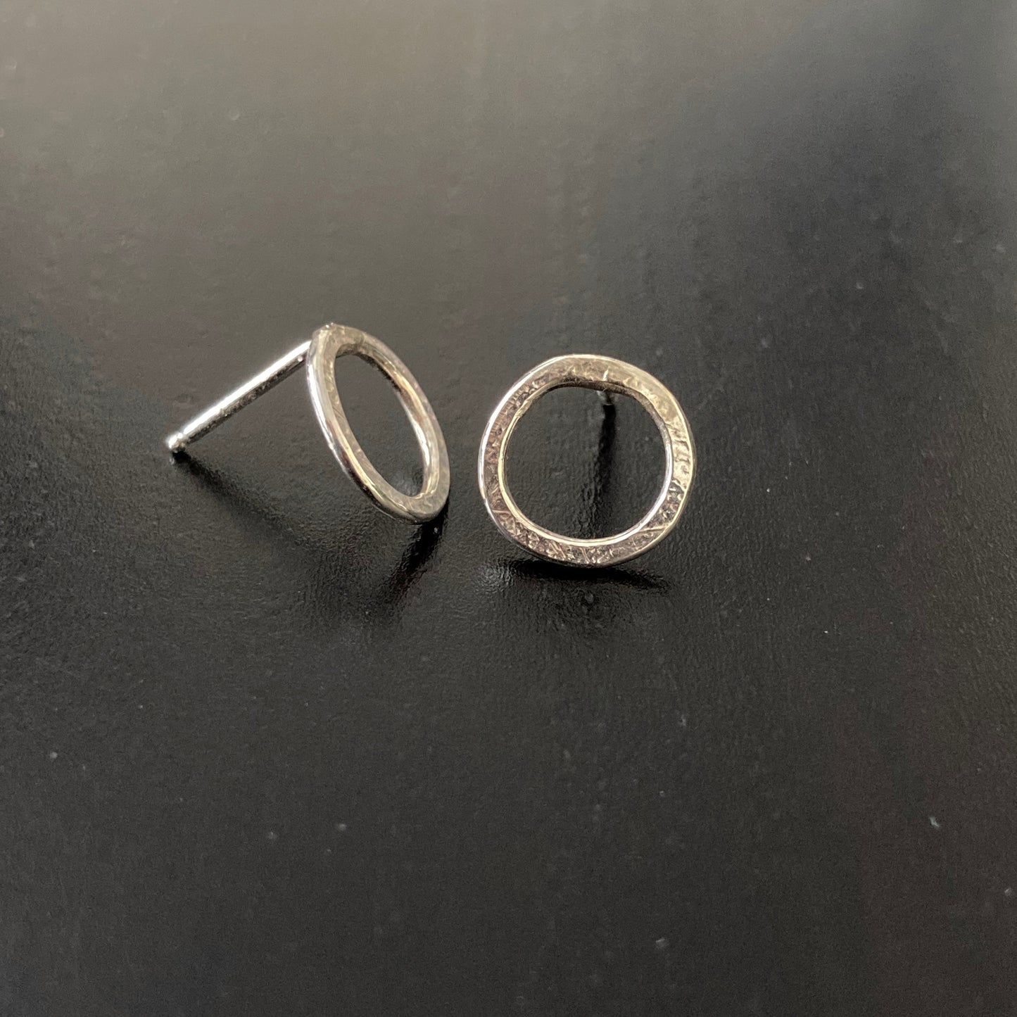 Small Silver Circle Post earrings shown on black background